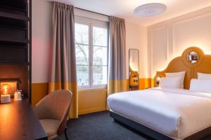 una habitación de hotel con una cama y una silla en LABE Hôtel Tours Centre Gare, en Tours