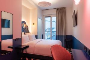 een hotelkamer met een bed en een spiegel bij LABE Hôtel Tours Centre Gare in Tours