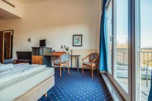 a hotel room with a bed and a desk at Landhotel Lewitz Mühle in Banzkow