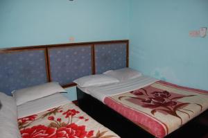 - deux lits assis l'un à côté de l'autre dans une pièce dans l'établissement Siddhartha Guest House, à Rummindei