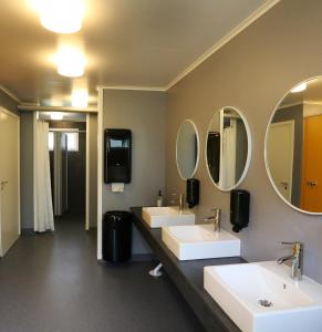 a bathroom with two sinks and two mirrors at Urshult Camping in Urshult