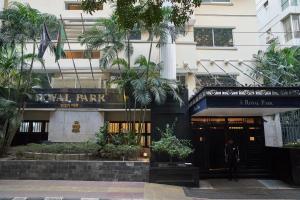Um homem está à porta do Royal Park Hotel em Singapura. em Royal Park Residence Hotel em Dhaka