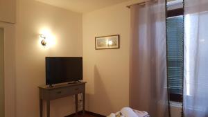 Zimmer mit TV auf einer Kommode mit Fenster in der Unterkunft Enchanting Verona in Verona