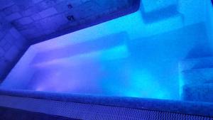 a bath tub with blue lights in a room at Trulli e Puglia Luxury Suite in Alberobello