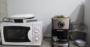 un forno a microonde e una macchinetta del caffè su un bancone di MyHouse 4 - Centro Sicilia Aeroporto Humanitas a Catania