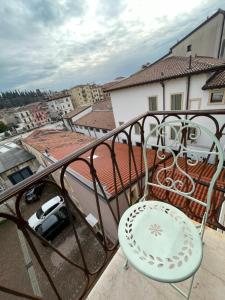 einen Stuhl auf einem Balkon mit Stadtblick in der Unterkunft Enchanting Verona in Verona