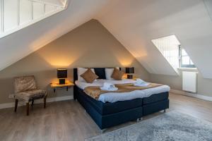 1 dormitorio con 1 cama y 1 silla en el ático en Najade Resort en Loosdrecht