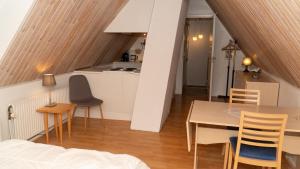 a room with a table and chairs and a kitchen at Plesners Anneks in Skagen