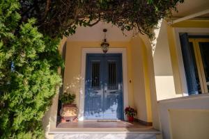 a blue front door of a house with two potted plants at Villa Elmar in Egina