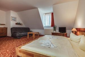 Habitación de hotel con cama y silla en Landhotel Lewitz Mühle, en Banzkow