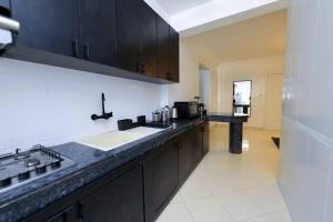 a kitchen with black cabinets and a counter top at TT Holidays - Rabat City Center in Rabat