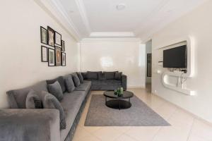 a living room with a couch and a tv at TT Holidays - Rabat City Center in Rabat