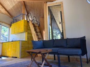 a living room with a blue couch and a table at Cabin on a Rock - Mountain Escape in Deçan