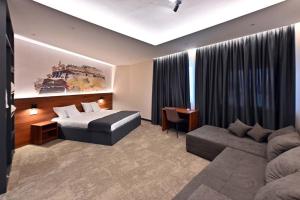 une chambre d'hôtel avec un lit et un canapé dans l'établissement Tvrdjava Rooms, à Novi Sad
