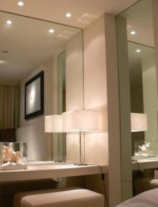 una camera da letto con specchio e tavolo con lampada di casagratia a Taormina
