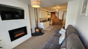 a living room with a couch and a fireplace at Pepperpot in Portreath