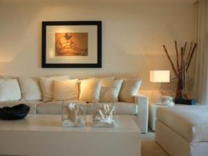 un soggiorno con divano bianco e tavolo di casagratia a Taormina