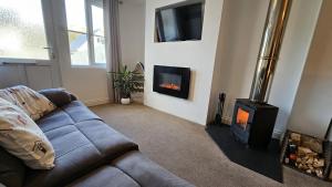 a living room with a couch and a fireplace at Pepperpot in Portreath