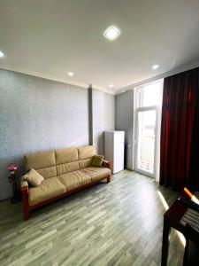 uma sala de estar com um sofá e uma janela em Kate's cozy apartment em Kutaisi