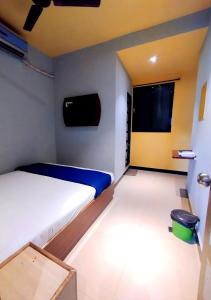 a small bedroom with a bed and a window at Hotel Aspen - Near International Airport in Mumbai