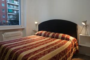 a bedroom with a bed with a blanket and a window at APARTMENT ON THE SQUARE in Rome
