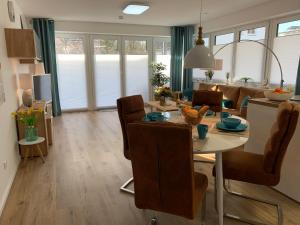 a dining room and living room with a table and chairs at Mein Ankerplatz in Travemünde