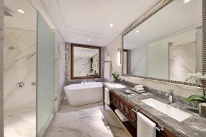 a bathroom with a tub and a large mirror at The Ritz-Carlton, Dubai in Dubai