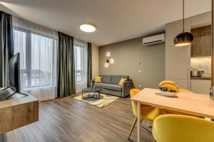 een woonkamer met een bank en een tafel met gele stoelen bij Mona Living in Sofia
