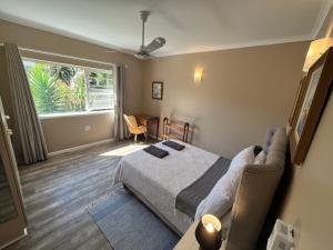 a bedroom with a bed and a table and a window at Whitewaters, 2 Bedroom Apartment in Sea View