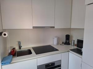 a kitchen with white cabinets and a stove top oven at Residentie Isis in Blankenberge