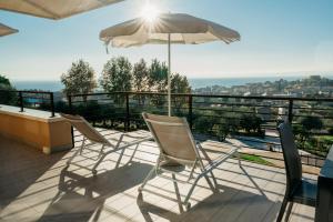 a patio with chairs and an umbrella on a balcony at Apartments Monsurei, Lake view in Bardolino