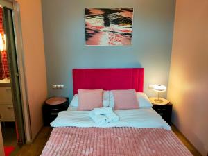 a bedroom with a large bed with a red headboard at Mirror Pink Studio Apartment in Krakow