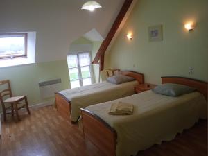 a bedroom with two beds and a window at Chambres d'hôtes Le Petit Angle in Saint-Broladre