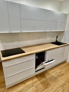 a kitchen with white cabinets and a sink at Sušilova 14 apartments II in Přerov
