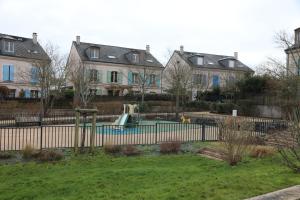 einen Hof mit einem Spielplatz vor einigen Häusern in der Unterkunft La suite Prestige de Saint Cyr in Saint-Cyr-lʼÉcole