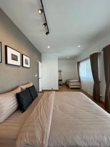 a large bed in a large room with a couch at AnnaHome89/63@Latkrabang in Ban Khlong Prawet