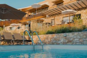 - une piscine avec des chaises et un parasol à côté d'un bâtiment dans l'établissement Apartments Monsurei, Lake view, à Bardolino