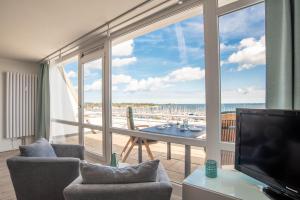 ein Wohnzimmer mit Blick auf den Strand in der Unterkunft Möwennest in Schilksee