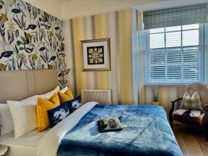 Atholl Arms Hotel Dunkeld في دنكيلد: غرفة نوم مع سرير مع لحاف أزرق