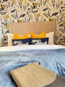 uma cama com um edredão azul e almofadas amarelas em Atholl Arms Hotel Dunkeld em Dunkeld
