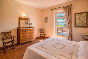 een slaapkamer met een bed, een dressoir en een raam bij Casale Le Pitte in Porto Azzurro