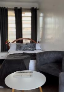 a bedroom with a bed and a table and a couch at Rooftop Studio Apartment - Mirema in Nairobi