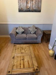 a living room with a couch and a wooden floor at Jesmond Vale 3 Bedroom Apartment in Newcastle upon Tyne