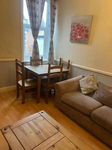 a living room with a couch and a table at Jesmond Vale 3 Bedroom Apartment in Newcastle upon Tyne