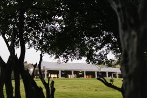 a large building in the middle of a field at Wildehondekloof Game Lodge in Matjiesrivier