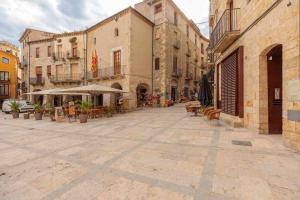 an empty street with tables and chairs and buildings at Can Bona Casa - Apartamento con vistas a la plaza in Besalú