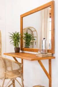 un espejo en una mesa de madera con dos plantas en MAKAI Surf House en Ahangama