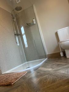 W łazience znajduje się prysznic ze szklanymi drzwiami. w obiekcie Kingarrow Cottage w mieście Omagh