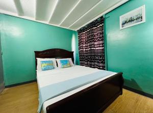 a bedroom with a bed with a blue wall at Casa Jessica 329 Dubai style One bedroom Corner unit plus loft in Bacoor