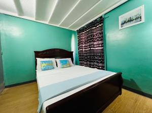 une chambre avec un lit avec un mur bleu dans l'établissement Casa Jessica 329 Dubai style One bedroom Corner unit, à Bacoor